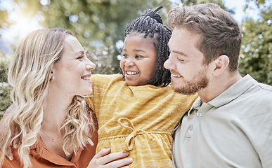 Image showing Adoption, hug and child with parents in a park with love, smile and happy for interracial family. Happiness, natural and African girl kid hugging her mother and father in a backyard or garden