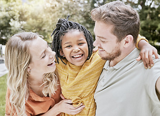 Image showing Happy family, parents and adoption kid at park, garden and nature for fun, bonding and quality time with love, care and happiness together. Smile black kid hug foster mom, dad and diversity people