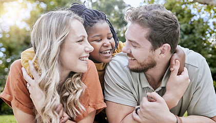 Image showing Happy family, adoption and child hug parents while relax together, bonding and enjoy outdoor quality time on park field. Love, parenthood and diversity family in nature for peace, freedom and calm