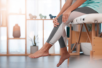 Image showing Healthcare, fitness and woman at physiotherapy for knee pain sitting in doctors office. Wellness, physical therapy and female with leg injury after exercise, workout and training in consultation room