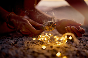 Image showing Hands, light and sage smoke at beach for healing or aromatherapy zen meditation. Woman, wellness and mental health in nature for mindfulness or spiritual chakra energy with fairy lights on ocean sand