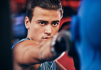 Image showing Fitness, boxing and athlete training at a gym for a fighting match with a punching bag and gloves. Motivation, martial arts and man boxer or fighter practicing for MMA competition at a sports center.