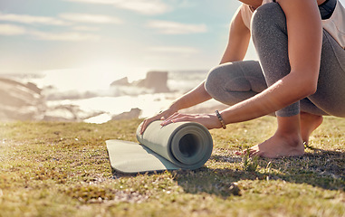 Image showing Woman, roll yoga mat and beach for meditation, outdoor and peace to relax or for wellness. African American female, healthy lady and grass start pilates, fitness and exercise at peaceful seaside