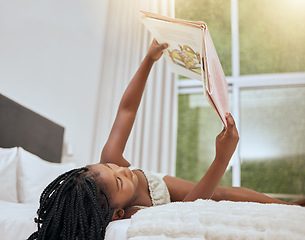 Image showing Kid reading story book in bed, relax and enjoy fairytale for entertainment, child development and literature. Story time, youth life growth and learning black girl read cartoon books in bedroom