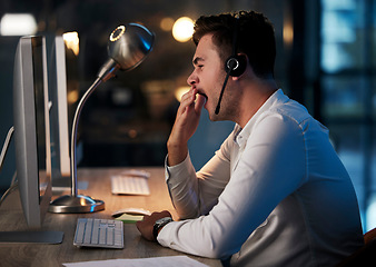 Image showing Tired, yawn and call center man in office at night for telemarketing, customer service and crm consulting. Exhausted, sleepy and overworked young call centre salesman with burnout and fatigue at desk