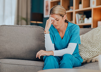 Image showing Worry, stress and burnout woman nurse sitting on sofa of modern apartment home sad with depression from work. Hand on head, anxiety and tired nursing in mental health distress on couch of living room