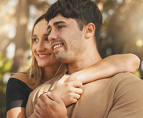 Image showing Love, happy and park with a couple hugging outdoor while enjoying the view together in nature. Face, bonding and date with a young male and female outside on a sunny summer day with affection