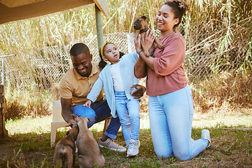 Image showing Family, dog adoption and pet outdoor with a happy mother, girl and dad with a puppy. Happiness, love and animal shelter care of a mom, child and man hug and hold dogs together with a smile in a park