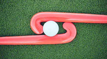 Image showing Hockey, ball and stick on green field, pitch and equipment against grass background after game, competition and match. Sports equipment, top view and astroturf with in practice, training and sport