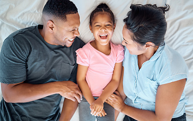 Image showing Happy family, top view and tickle kid in bedroom for love, care or relax in family home. Above of laughing, smile and playful parents, excited girl child and happiness of funny time together in house