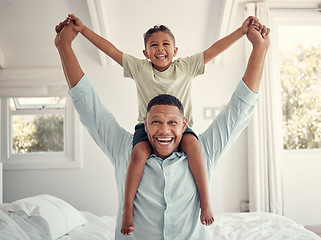 Image showing Father, child and smile for bedroom piggyback relaxing or fun playful bonding together at home. Happy dad and kid holding hands on shoulders for family time, relax and playing joy on the bed indoors