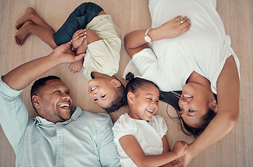 Image showing Top view, happy family or bonding on floor in house living room, family home bedroom or Indonesian hotel. Smile, children or kids with mother, father or parents lying on ground in trust, play or love