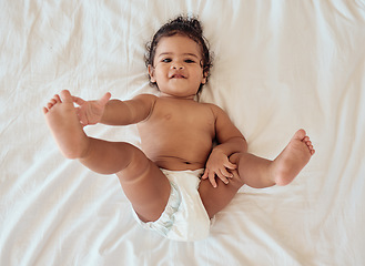 Image showing Happy, smile and portrait of a baby with a diaper relaxing on a bed in his bedroom or nursery. Happiness, health and toddler kid by with a disposable nappy laying and relaxing in room at family home.