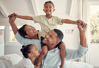 Image showing Mother, father and kids, a happy family playing on bed in home, smile and laugh with piggy back on holiday weekend. Love, fun and family time for dad, mom and children in family bedroom in Brazil.