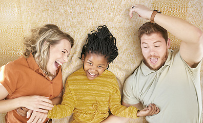 Image showing Happy, adoption and interracial family relaxing, playing and bonding together in their home. Happiness, love and multiracial parents with their girl child resting in the living room of a modern house