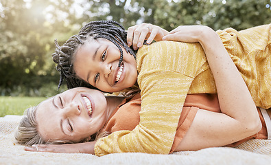 Image showing Happy family, mother hug and nature of a interracial girl and mama with love in a picnic park. Portrait of happy, relax and smile of a mother and daughter together on a floor with diversity adoption