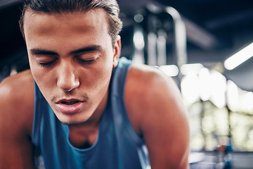 Image showing Tired, gym and fatigue man breathing, break and workout, training or exercising inside a wellness club. Young athlete or cardio guy bending after his fitness strength or muscle exercise for health