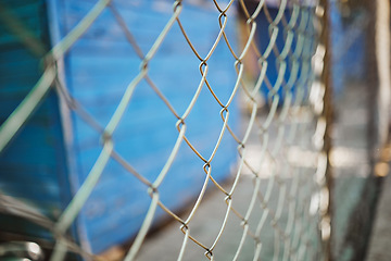Image showing Steel, iron or metal fence for safety with a blurred background at an outdoor shelter or clinic. Chain link, veterinary and closeup of a wire barrier for security outside with enclosure or barricade.