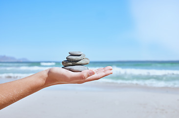 Image showing Rock balance, hand and beach for meditation, yoga or peace exercise in nature by water, Hands holding rocks for chakra, outdoor meditate and spiritual wellness, health and holistic training by sea