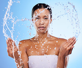 Image showing Portrait, water splash and skincare woman for beauty, moisture or self care by blue background. Black woman, skin model and cleaning face for health, dermatology or wellness with natural cosmetics