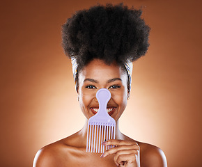 Image showing Comb, black woman and hair care with smile, afro and natural beauty for health against brown studio background. Cosmetics portrait, hair product and African American female being happy, confident