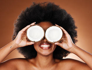 Image showing Coconut oil, black woman and beauty for natural cosmetics, healthy lifestyle and facial skincare on studio background. Happy african model cover eyes with tropical summer fruit for wellness nutrition