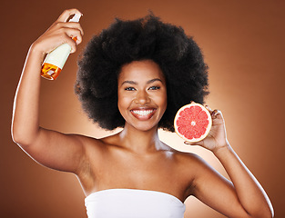 Image showing Grapefruit, black woman and afro hair spray, beauty and serum in hair care maintenance, aesthetic wellness or natural cosmetics on studio background. Portrait african model, citrus oil and curly hair