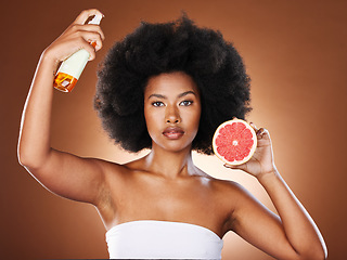 Image showing Black woman, hair care and beauty with spray, studio or wellness in portrait, health or afro with grapefruit. Woman, model and african girl with fruit, cosmetics or self care with by brown background