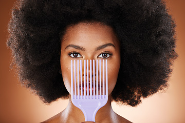 Image showing Beauty, hair care and black woman with an afro comb in a studio isolated by a brown background. Health, wellness and portrait of a African model with big beautiful natural curly hair and a brush.