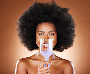 Image showing Black woman afro, comb and smile for hair care, style or fashion against a studio background. Portrait of African American female smiling in satisfaction for beauty hairstyle or salon treatment