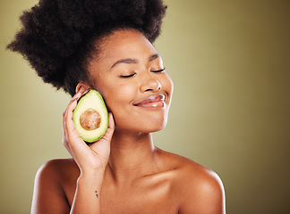 Image showing Face, skincare and black woman with avocado for health, wellness and nutrition on green background. Eyes closed, healthy food and antioxidant diet of happy female model from Nigeria with glowing skin