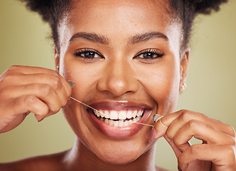 Image showing Floss, teeth and portrait of a black woman with dental, dentist and mouth wellness promotion in green studio. Young african model, tooth cleaning product and dental floss for healthcare advertising
