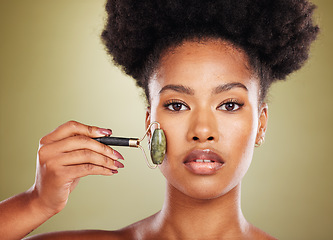 Image showing Skincare, face roller and black woman in studio portrait with facial massage for natural beauty, cosmetics and facial wellness product. African beauty model with stone rose quartz in dermatology care