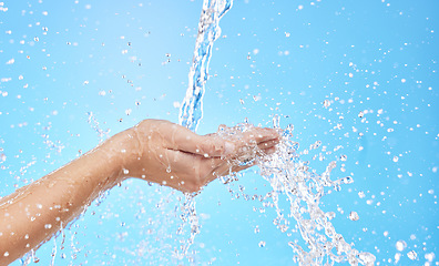 Image showing Hands, water splash and cleaning skin, bacteria and hygiene for blue studio background with mockup space. Hand rinsing, washing or clean for fresh hygienic cleanse or hydration in care for skincare