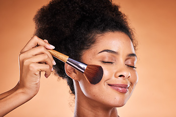 Image showing Face, beauty and blusher with a black woman model in studio on a beige background to apply blush to her cheek. Makeup, cosmetics and luxury with an attractive young female using a product on her skin