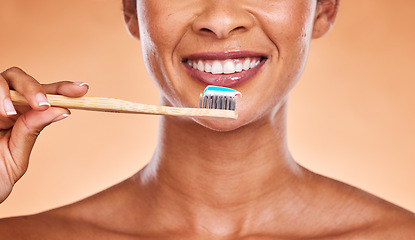 Image showing Studio, dental and black woman brushing teeth on orange background. Wellness, oral health or routine of happy female model holding toothbrush and cleaning teeth for hygiene, oral care and dental care