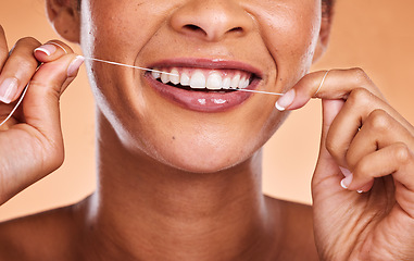 Image showing Woman, hands and teeth with smile for dental floss, skincare or personal hygiene against a studio background. Closeup of female smiling and flossing in cosmetics for oral, mouth or gum care treatment