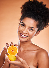Image showing Black woman, afro hair and orange fruit on studio background for vitamin c skincare, dermatology or blemish treatment. Portrait, smile or happy beauty model with citrus health food for wellness diet