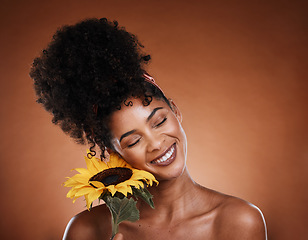 Image showing Sunflower, beauty and black woman in studio for skincare glow, wellness and cosmetics benefits with promotion, marketing and advertising space. Young model with natural flower for hair and skin care