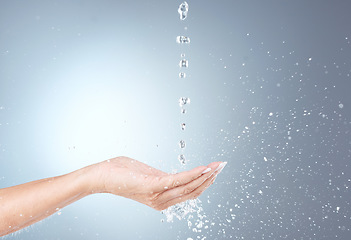 Image showing Water, stream and isolated hand in studio on gray background for wellness, cleaning and hydration. Healthcare, body care and woman cleanse, hydrate and washing hands with water splash for hygiene