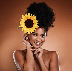 Image showing Beauty, skincare and black woman with flower in hair, portrait of happy lady with salon afro hairstyle, and smile on face. Nature, natural organic skin and haircare product for woman with sunflower.