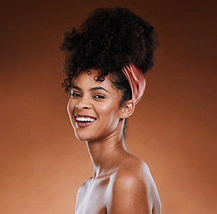 Image showing Hair care, skincare and black woman with a smile for beauty against a brown studio background. Wellness, happy and portrait of an African girl model with makeup, cosmetics and routine grooming