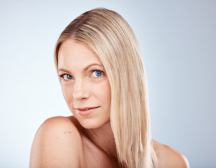 Image showing Portrait, hair and natural with a model woman in studio on a gray background for wellness or treatment. Face, haircare and face with an attractive young female posing to promote a keratin product