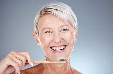 Image showing Portrait, senior woman and brushing teeth for dental hygiene, fresh breath and smile against grey studio background. Oral health, mature female and elderly lady with toothbrush and cleaning mouth.