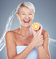 Image showing Woman, water splash and lemon for senior healthcare or skincare beauty. Elderly model, vitamin c nutrition and cosmetic wellness or natural body care, happy and relax shower in grey background studio