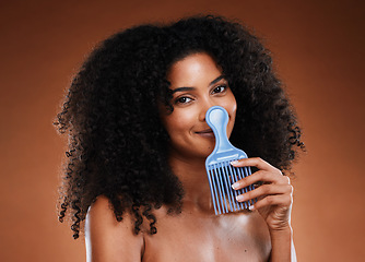 Image showing Curly hair comb, beauty and black woman with afro hairstyle, cosmetics and perm on studio background. Portrait happy young african girl, hair brush and natural hair care, fashion and funky hair style