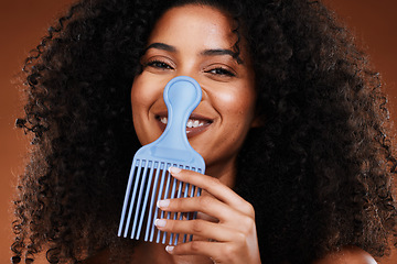 Image showing Black woman, curly hair comb and afro beauty, hairstyle and hair care on studio background. Portrait happy african girl model, hair brush or hair styling tool in fashion, cosmetics and natural trends