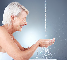 Image showing Skincare, happy and senior woman with water for face, beauty and hydration against a grey studio background. Cleaning, wellness and elderly model with a smile for hygiene and grooming with liquid