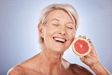 Image showing Skincare, beauty and senior woman with a grapefruit for health, wellness and facial beauty against a grey mockup studio background. Excited, happy and elderly model with a smile for a fruit diet