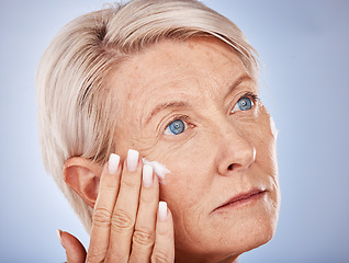 Image showing Mature woman, cream and apply face cream or lotion for wrinkle anti aging on a grey studio background. Spf, suncream with a senior female apply sunscreen for health, wellness and protection